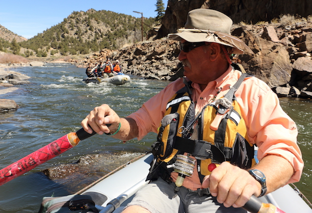 Bill Dvorak, Dvorak Rafting, Kayaking and Fishing Expeditions owner, navigates the narrow Arkansas River with fishers on board and rafters behind.