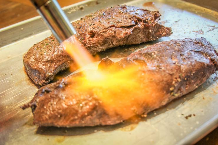 searing the cooked backstrap with a blowtorch sous vide venison backstrap