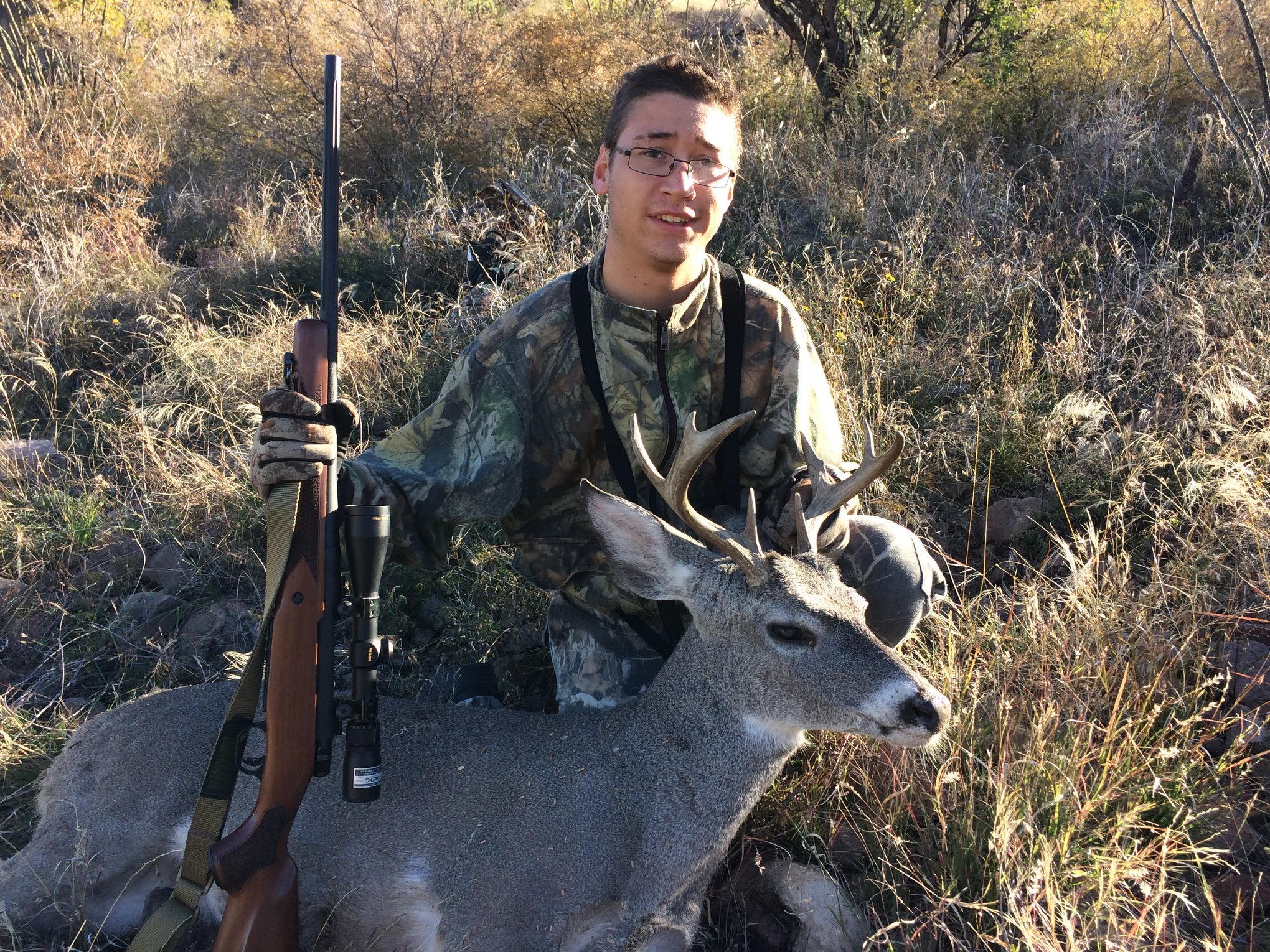 Teenage boy with 8-point Coues deer buck he has shot