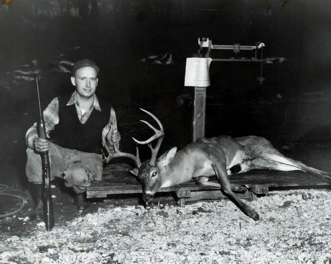 black and white photo of hunter with deer