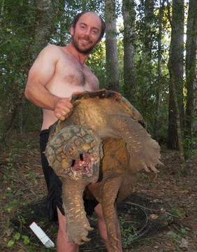 Man holding 105-pound snapping turtle