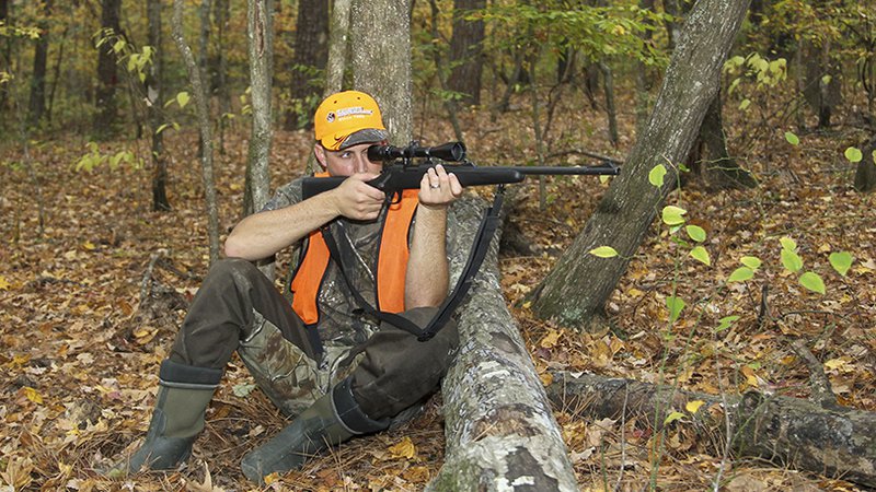 deer hunter aiming rifle