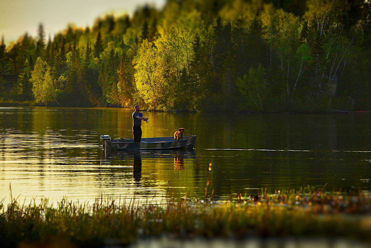 fisherman on lake with dog